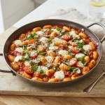 Gnocchi in Tomatensauce mit geschmolzenem Mozzarella und Basilikum in einer Pfanne